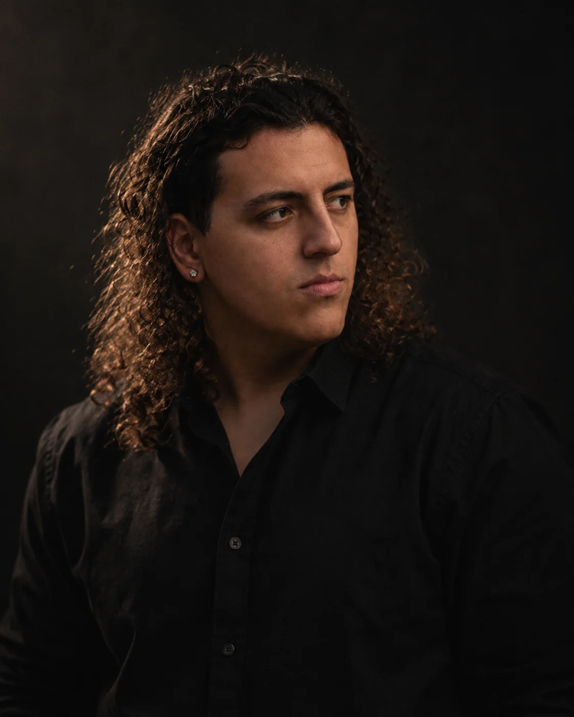 Julian Johnson looking off to the side, warm light in his hair